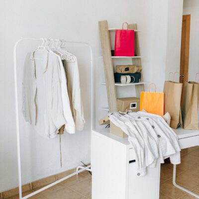 A modern interior with shopping bags, clothing rack, and minimalist design elements.